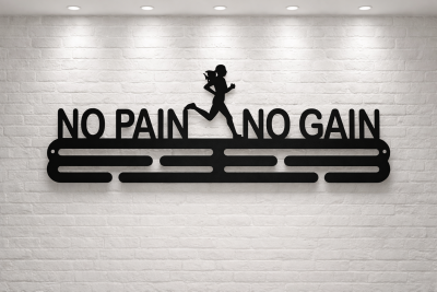 Medalhanger de metal preto com frase motivacional montado em parede de tijolo branco