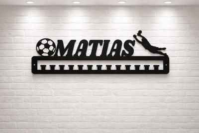 Suporte de medalhas preto com nome MATIAS e figura de guarda-redes a defender uma bola