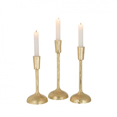 Conjunto de três castiçais dourados com velas brancas acesas