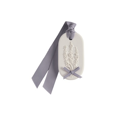 Marcador de livro ou decoração em cerâmica branco com fitas cinzentas e ornamento floral em relevo.