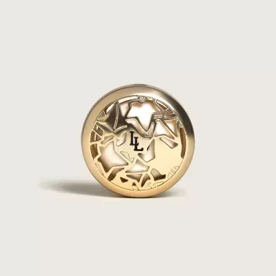 Botão dourado redondo com design recortado abstrato e letras LL no centro