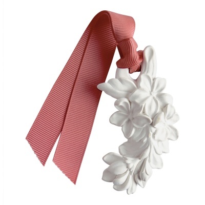 Ornamento branco em relevo com flores pendurado em fita rosa