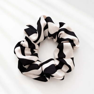 Scrunchie preto e branco com padrão de faixas largas e onduladas