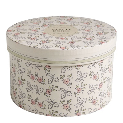 Caixa redonda decorativa com padrão floral em verde e rosa e etiqueta VARELLI DORÉE