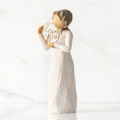 Estátua decorativa de mulher com vestido branco segurando aro dourado com texto 'love you'.