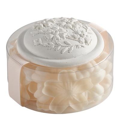 Potinho transparente com sabonetes florais creme e tampa branca decorada.