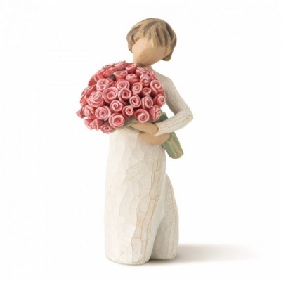 Escultura de figura feminina com vestido branco segurando ramo de rosas cor-de-rosa em madeira