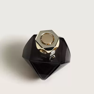 frasco de perfume preto com tampa dourada hexagonal