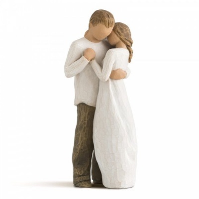 Escultura de casal em abraço, homem com camisola branca e calças castanhas, mulher com vestido branco comprido