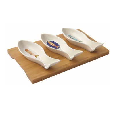 Conjunto de três pratos em forma de peixe com desenhos de sardinhas sobre uma tábua de madeira