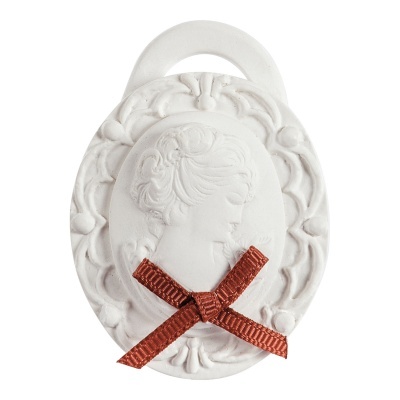 Medalhão oval branco com relevo de perfil feminino e laço vermelho