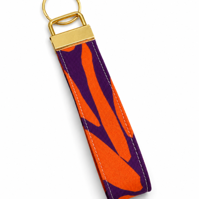 Chaveiro de tecido com padrão laranja e roxo e argola dourada