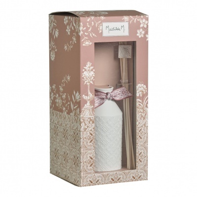 Frasco branco cerâmico decorativo com pauzinhos aromáticos numa caixa rosa com padrão floral