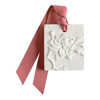 Pendente decorativo branco com relevo floral e fita rosa