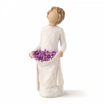 Estátua de figura feminina com vestido branco segurando flores lilás