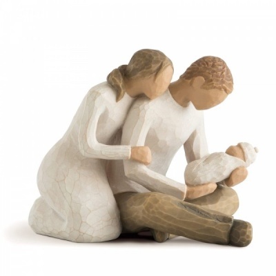 Escultura de família em madeira com duas figuras adultas e um bebé