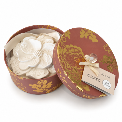 Caixa redonda decorativa vermelha com estampado dourado e peças decorativas brancas em forma de flor