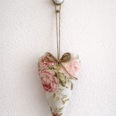 Almofada coração com tecido floral pendurada na parede