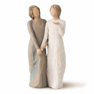 Escultura rústica de duas mulheres com vestido longo cinza e branco