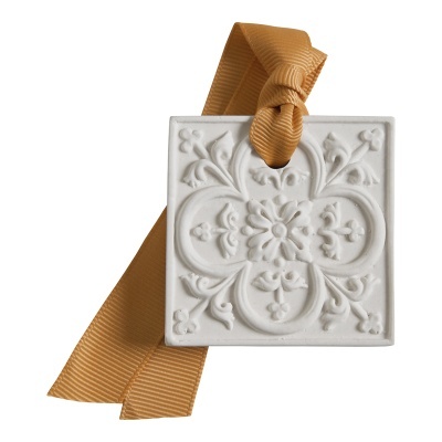 Peça decorativa quadrada branca com motivo floral em relevo e fita castanha