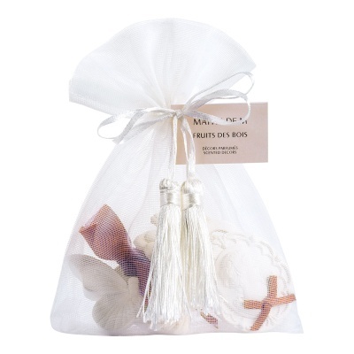 Saco branco translúcido com laço e borlas, decorado com elementos naturais castanhos e creme e etiqueta