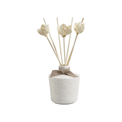 frasco decorativo branco com palitos e flores artificiais