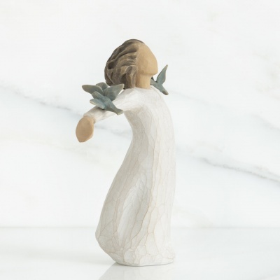 Escultura de figura feminina com vestido branco e flores verdes