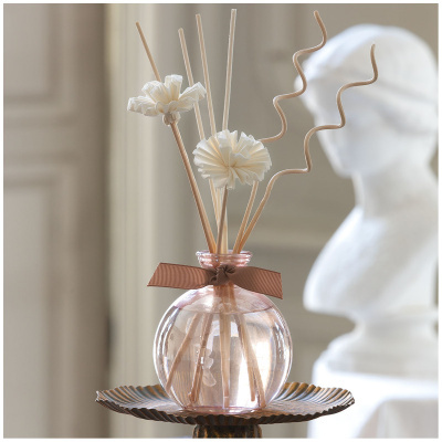 Difusor de aromas vidro rosa com paus de madeira e decoração floral natural