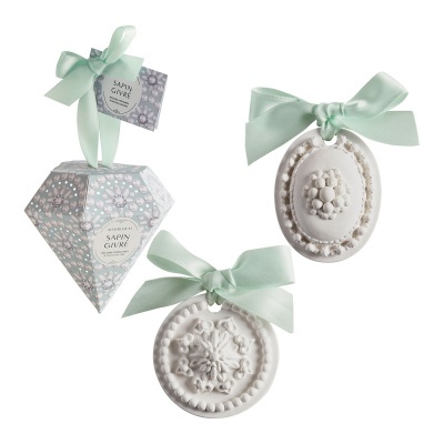 Decorações brancas em relevo com laços verdes e embalagem hexagonal decorada