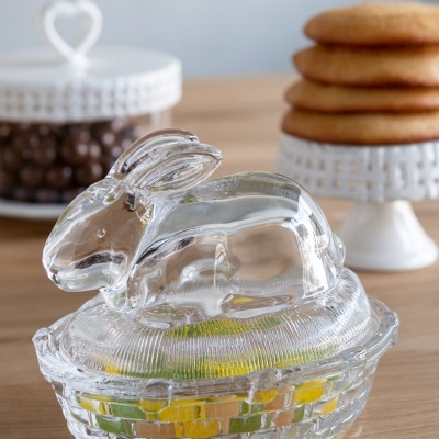 Recipiente de vidro transparente em forma de coelho com tampa e base texturizadas.