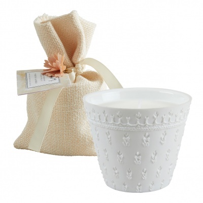 Vela decorativa branca com textura floral e saco de juta