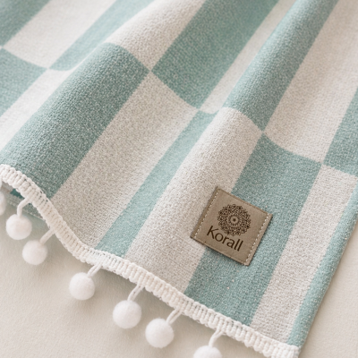 Pano riscado verde e branco com pompons e etiqueta Korall