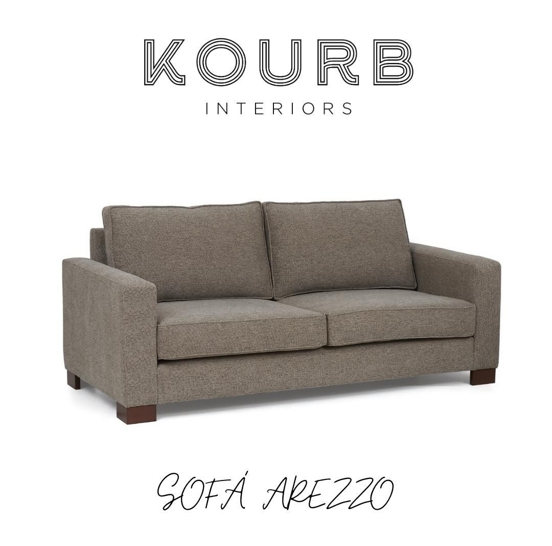 Sofá Arezzo cinzento de dois lugares com pés de madeira escura e texto KOURB INTERIORS