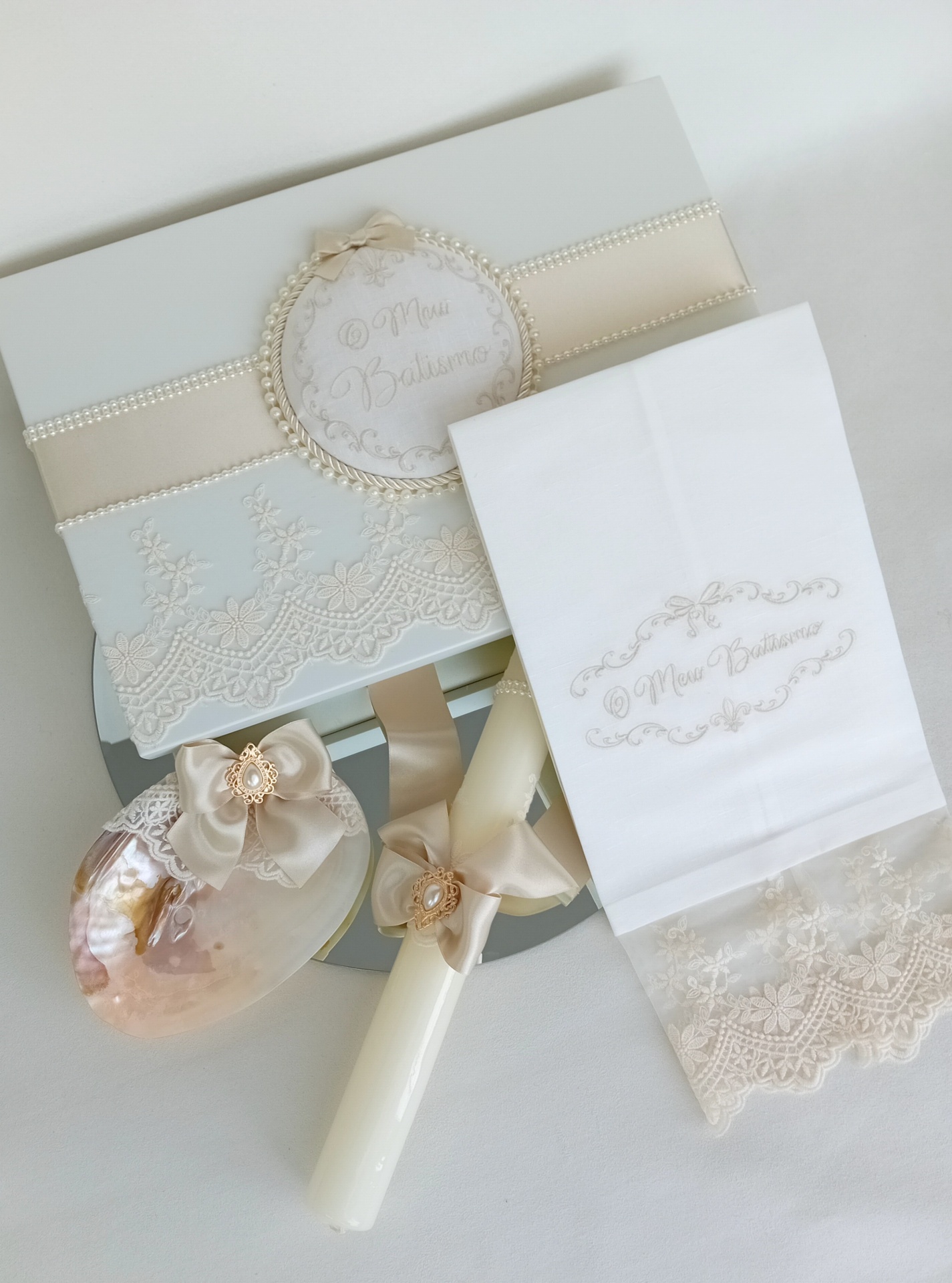 Conjunto de batismo com vela, concha, toalha e caixa decorados com laços e pérolas