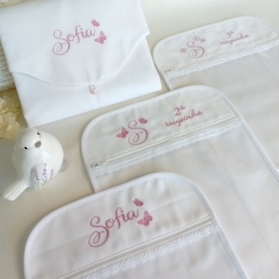 sacos em tecido branco com bordados rosa, detalhes em renda, acompanhados por caixa também bordada