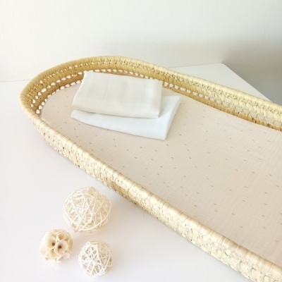 Cesto oval de palha natural com base almofadada bege e bolas decorativas brancas