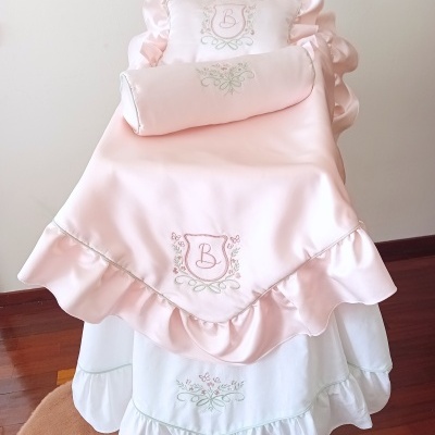 Cobertura de berço rosa claro com babados e bordado com letra B