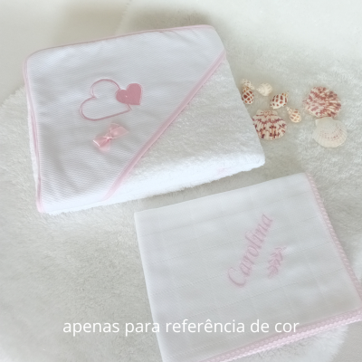 Toalha e pano de bebé brancos com detalhes rosa e conchas marinhas ao lado