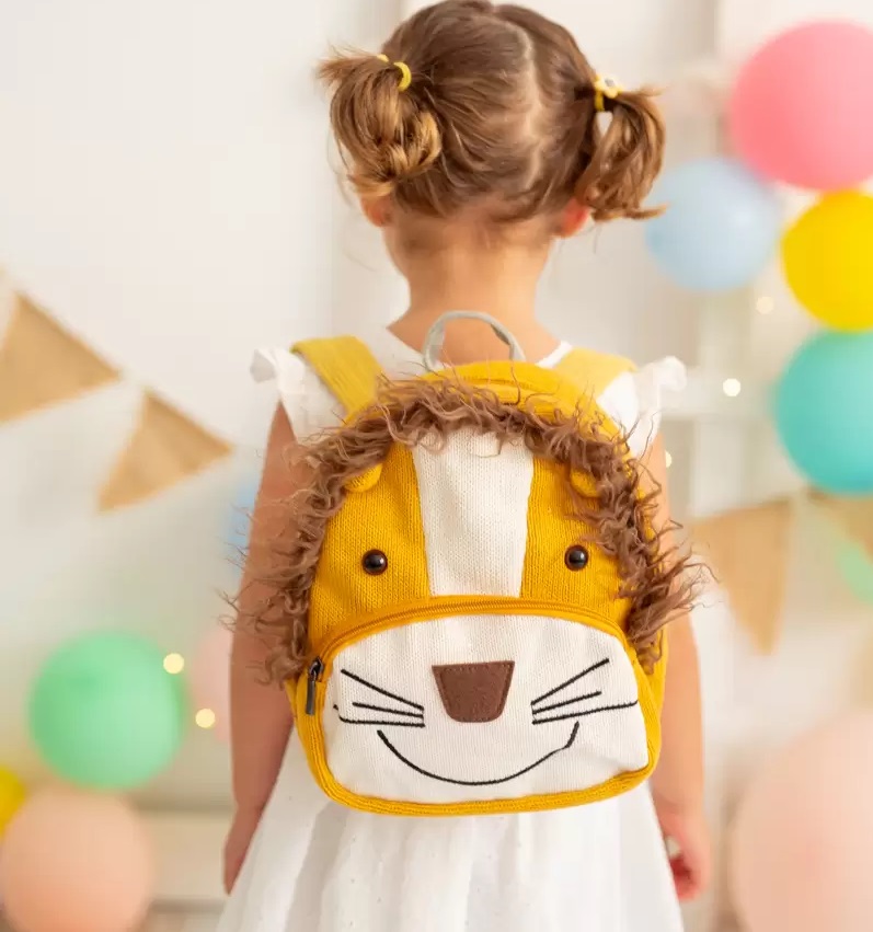 Mochila Simba Mochila infantil amarela em forma de leão com pelo castanho e detalhes em preto usada por criança