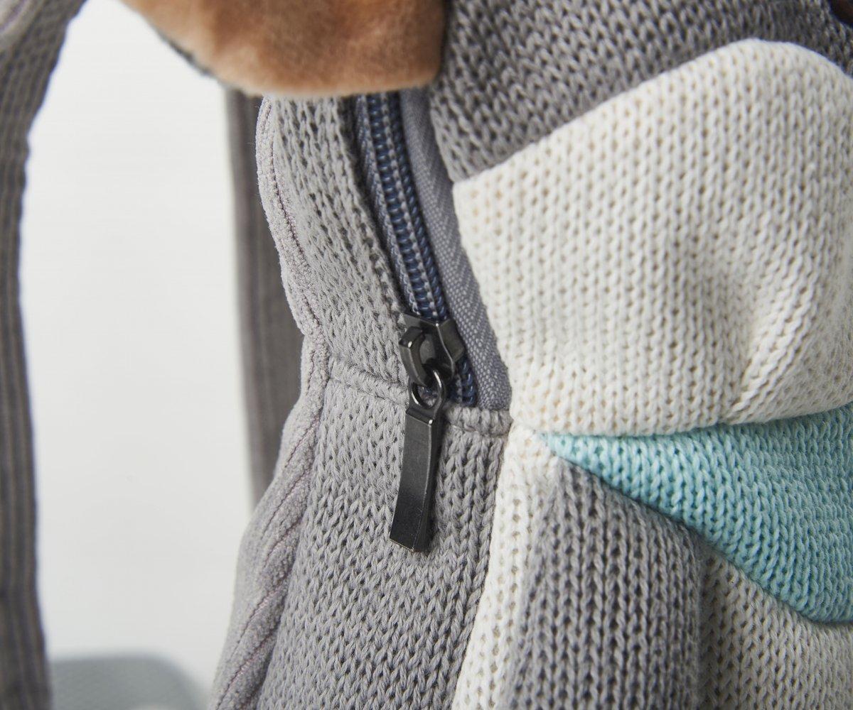 Mochila Ratita Fecho éclair preto numa peça de tecido cinzento com padrão malha e detalhes em branco e azul