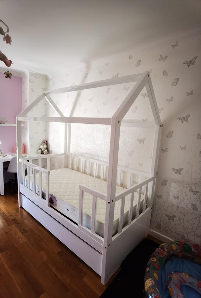 Cama infantil branca em forma de casinha com grades e colchão acolchoado