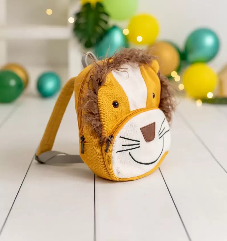 Mochila Simba Mochila infantil amarela com design de leão e pêlo castanho em fundo com balões