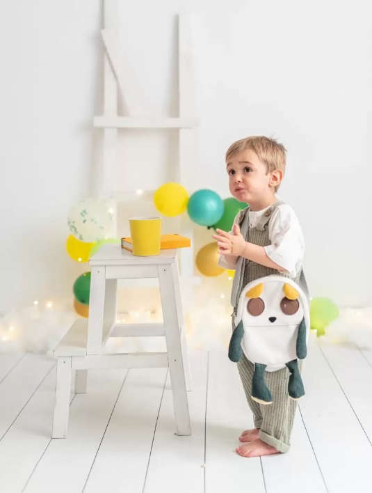 Mala Cuki Criança com mochila de pelúcia e balões coloridos