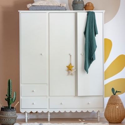 Guarda-roupa branco com três portas, três gavetas e decoração de estrelas penduradas