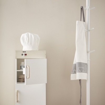 Móvel de cozinha de madeira clara com chapéu de cozinheiro, avental e cabide branco com estrela no topo