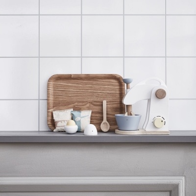 Utensílios de cozinha em tons neutros sobre bancada com parede branca de azulejos