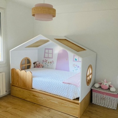 Cama infantil em forma de casa com decoração rosa e madeira clara