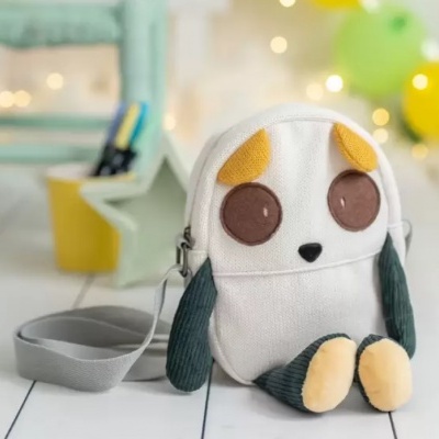 Mala pequena com forma de animal em tecido branco e detalhes castanhos e amarelos