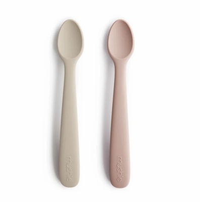 Duas colheres de silicone, uma bege e uma rosa claro, com a palavra MUSHIE na haste