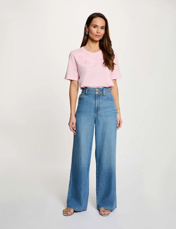 Pilofi Wide Leg Jeans Mulher com t-shirt rosa e jeans azul de perna larga em fundo branco